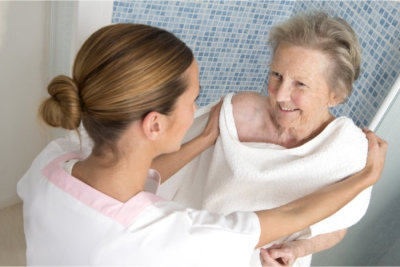 elder woman taking a bath with her caregiver