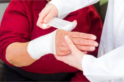 doctor bandaging the elderly woman's hand